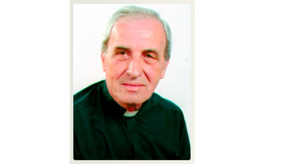 Portrait of an older man with short gray hair wearing a black clerical shirt and collar.