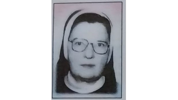 Framed black-and-white photo of a nun wearing a habit and glasses, looking at the camera.
